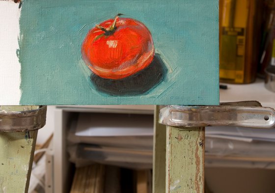 modern still life of very red tomato on a blue background