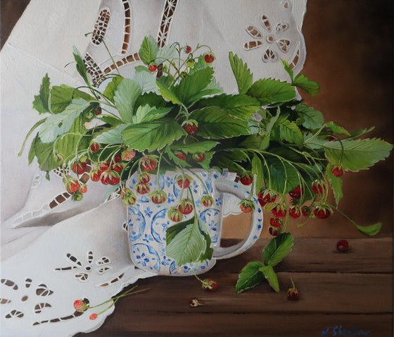 Bouquet of wild strawberry branches in a cup