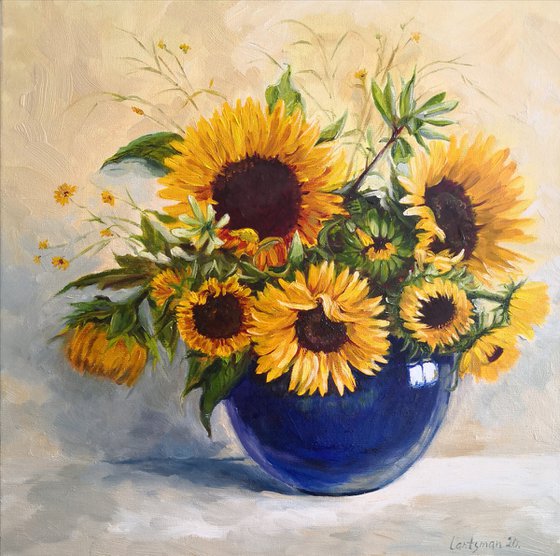 Sunflowers bouquet in a blue glass vase still life