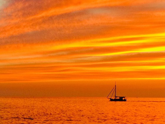 SUNSET AT THE SEA WITH A BOAT