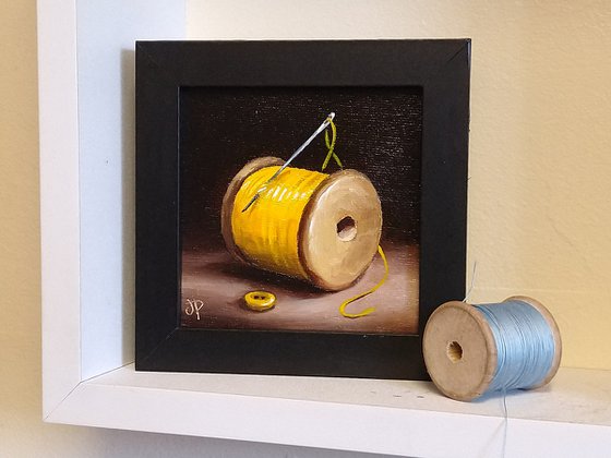 Little yellow cotton reel with button still life