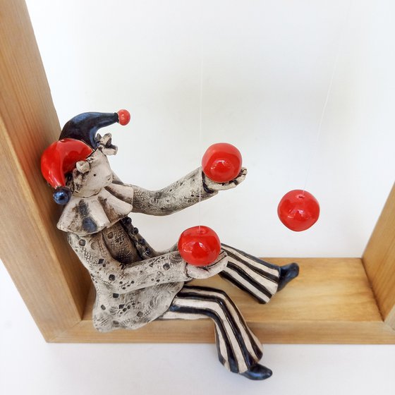 A clown playing with balls