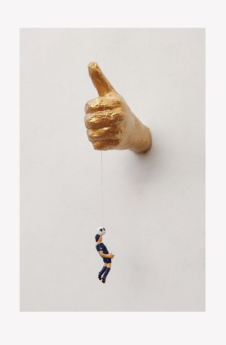 Hand holding football player - Original paper sculpture by Shweta Mahajan