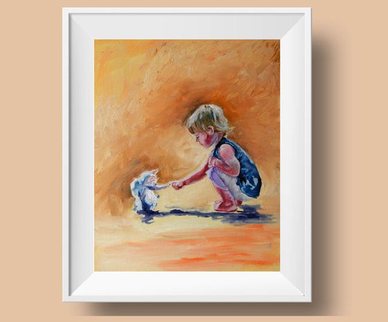 A Boy playing with a cat/kitten.