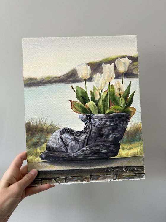 White tulips in old shoe planter sea view