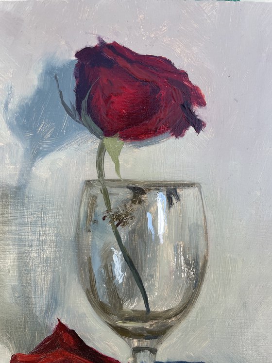 Red rose in empty glass