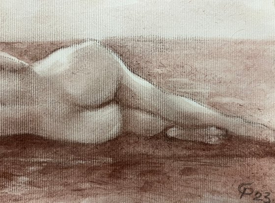 Nude woman from behind lying down on beach