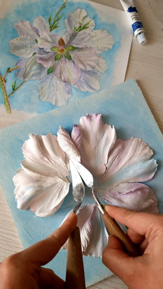 White delicate almonds on a blue background. A small floral botanical relief. 3d painting of spring flowers with ceramic petals.