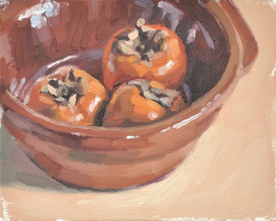 Persimmons in an earthenware dish