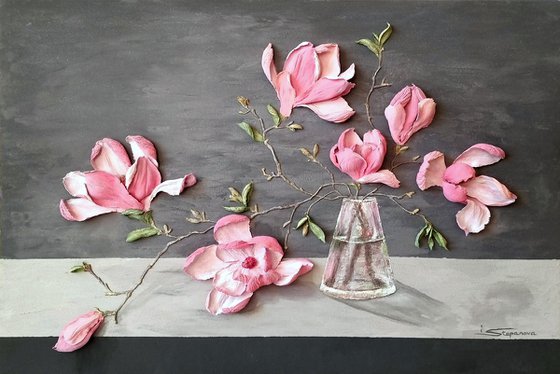 Pink Magnolia on a gray background. Relief still life with a branch of large flowers in a glass vase. Spring blooming