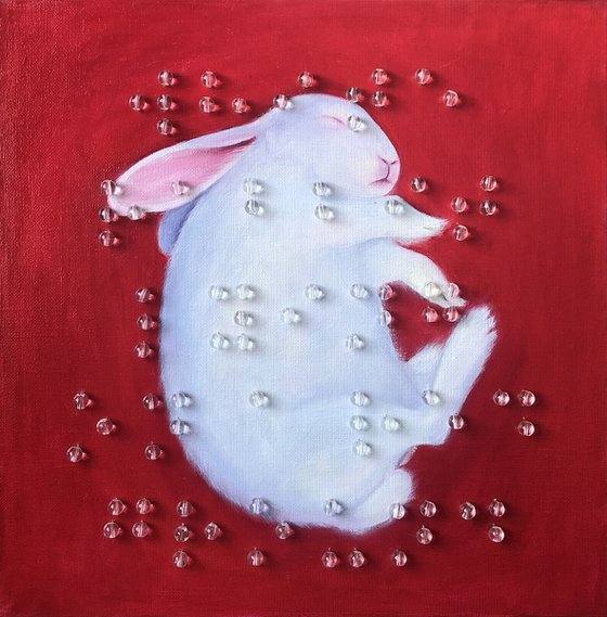 White rabbit lying on a red ground