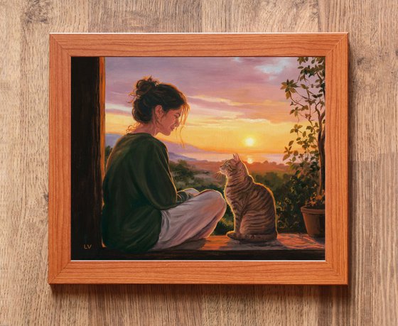 Girl watching the sunset with her tabby cat