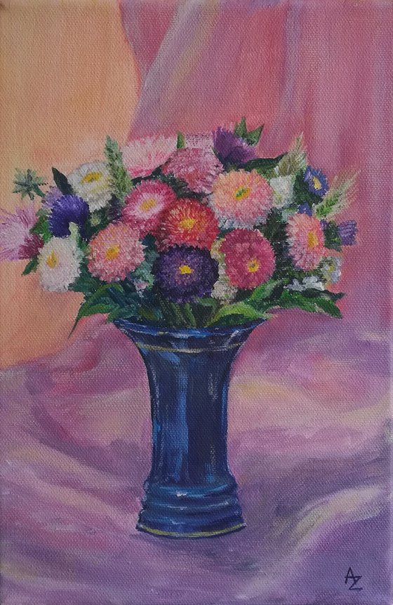 A small bouquet of asters in a blue vase