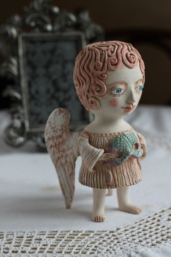 Angel holding a mask. Ceramic OOAK sculpture.