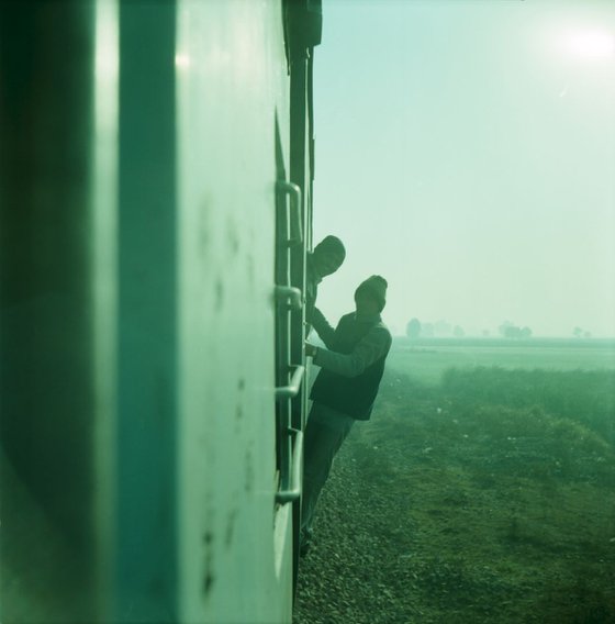 Travellers hanging off train