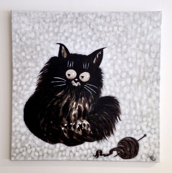 Black cat with a ball of wool
