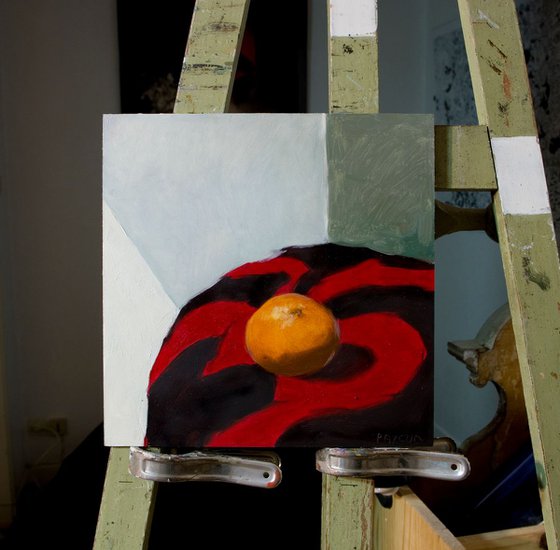 modern still life of tangerine on red and black