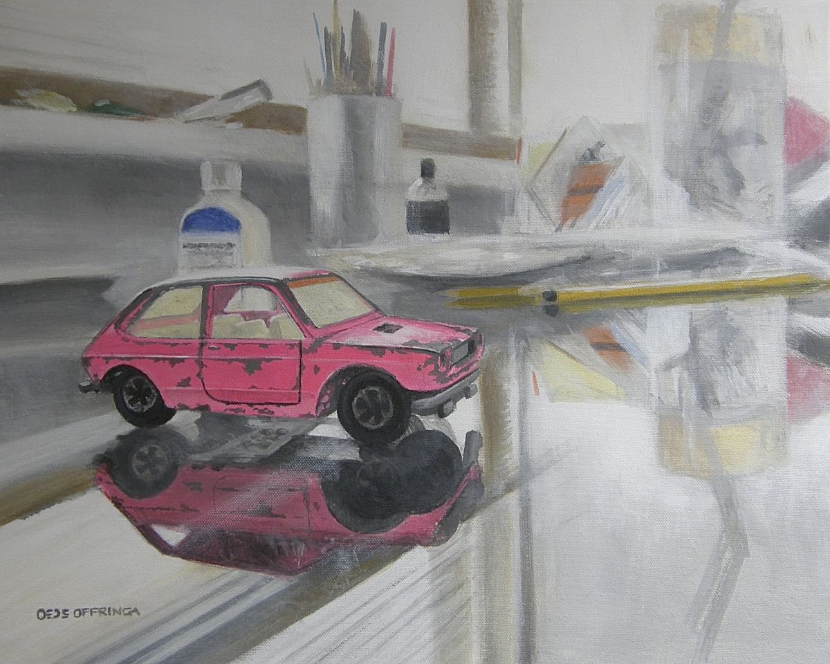Old little pink Fiat on a glass desktop. by Oeds Offringa