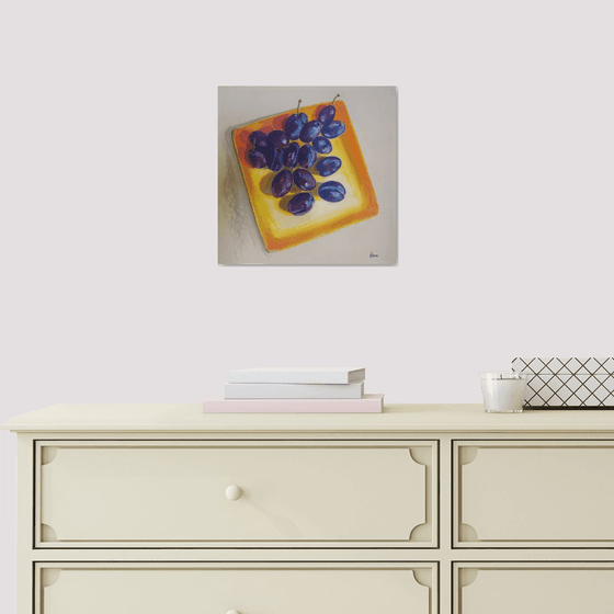 Blue plums on a yellow dish