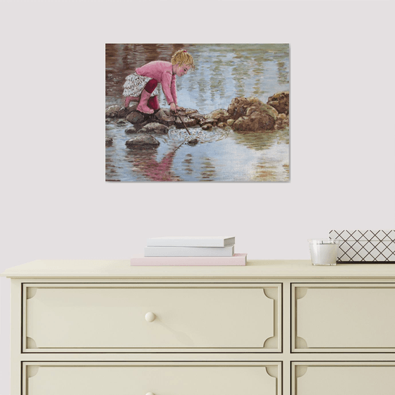 Girl in pink boots playing by a lake