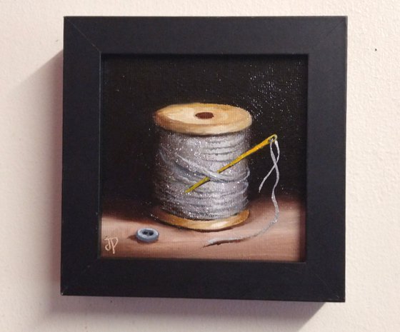 Little silver thread with golden needle still life