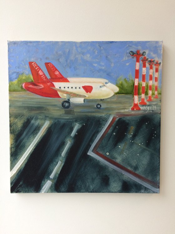 Two red and white airplanes on airfield