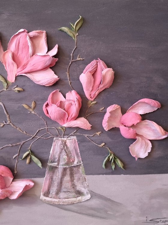 Pink Magnolia on a gray background. Relief still life with a branch of large flowers in a glass vase. Spring blooming