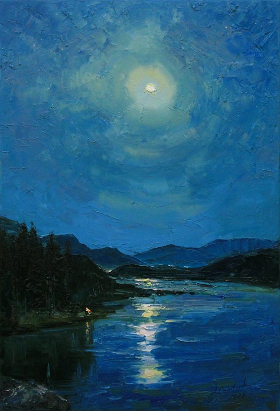 Full moon in blue sky over river