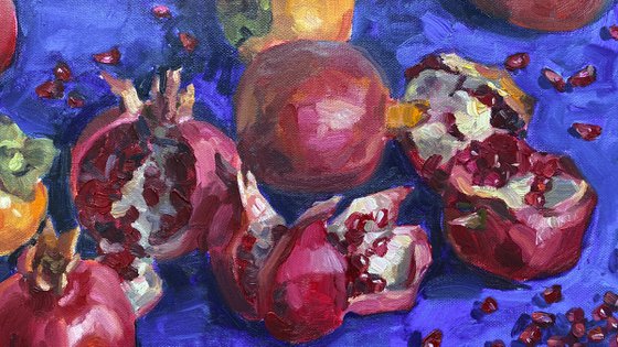 Pomegranates and persimmons on blue