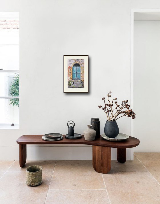 A cat at an old turquoise door