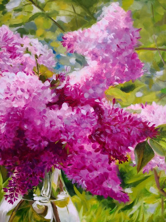 Lilac bouquet in a glass vase in the garden still life