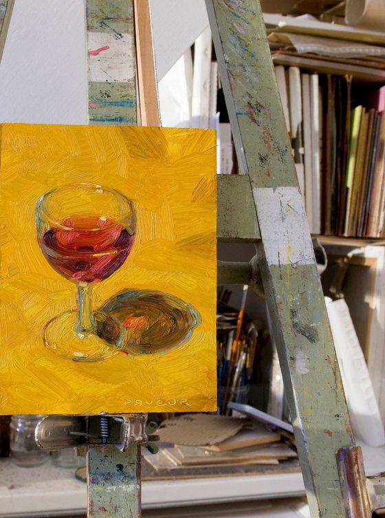 glass of red wine on yellow