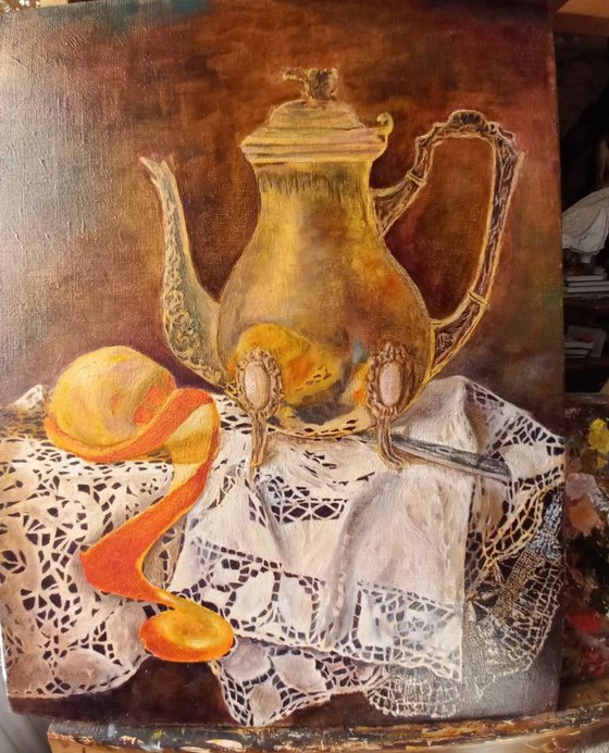 Silver coffee pot with orange on a linen tablecloth