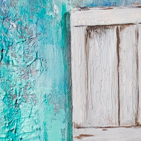 A window in an old turquoise wall