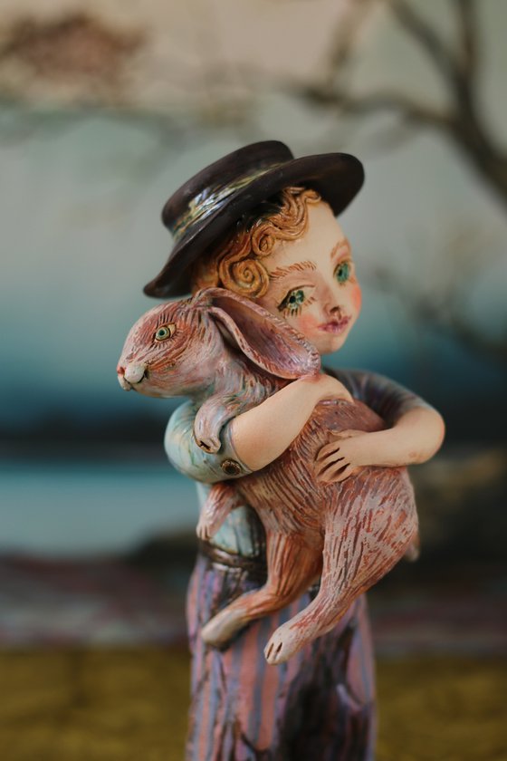 Vintage dressed boy holding a rabbit.
