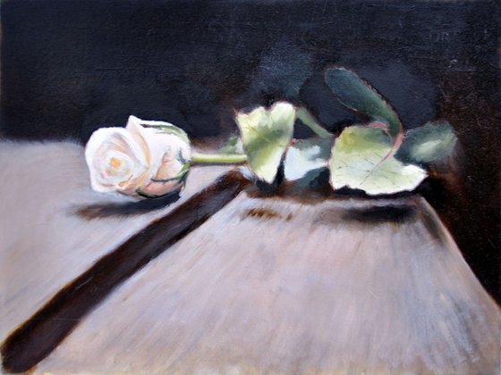 One white rose on the wooden table