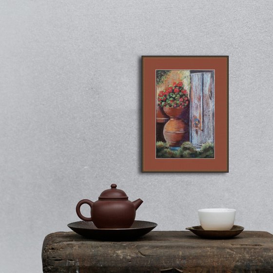 Pot with geraniums at the old door