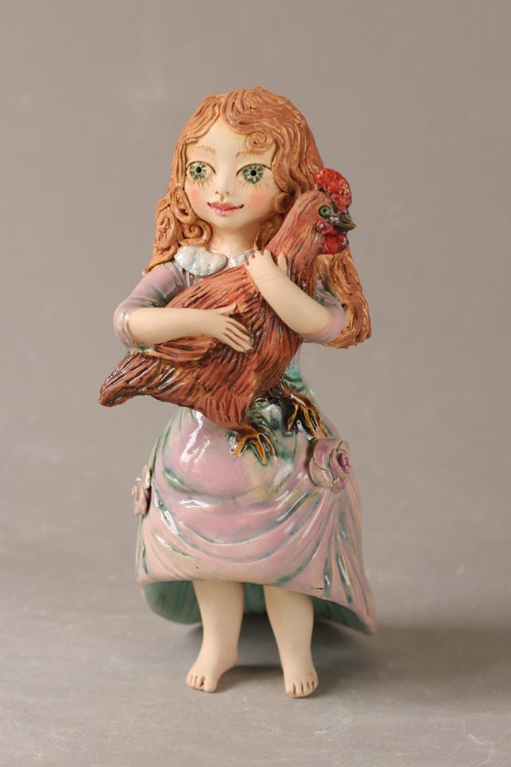 Vintage dressed girl holding a chicken.