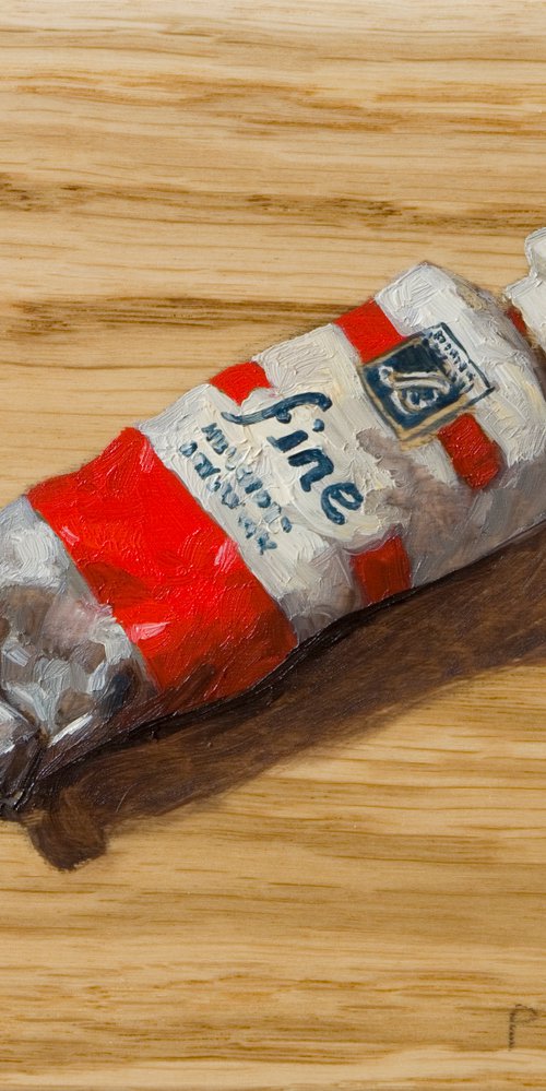 modern still life of a red color painting tube on a plank board by Olivier Payeur