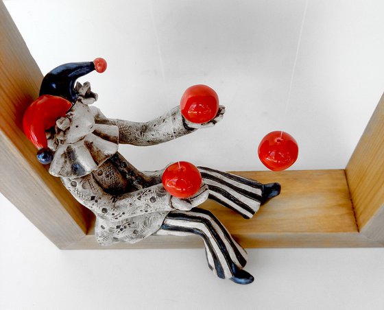 A clown playing with balls