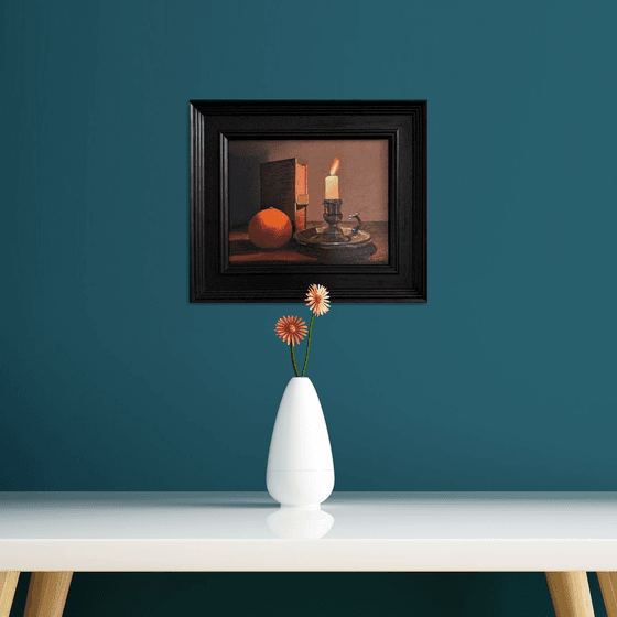 Candlelight still life with Victorian book and orange; Framed, ready to hang.