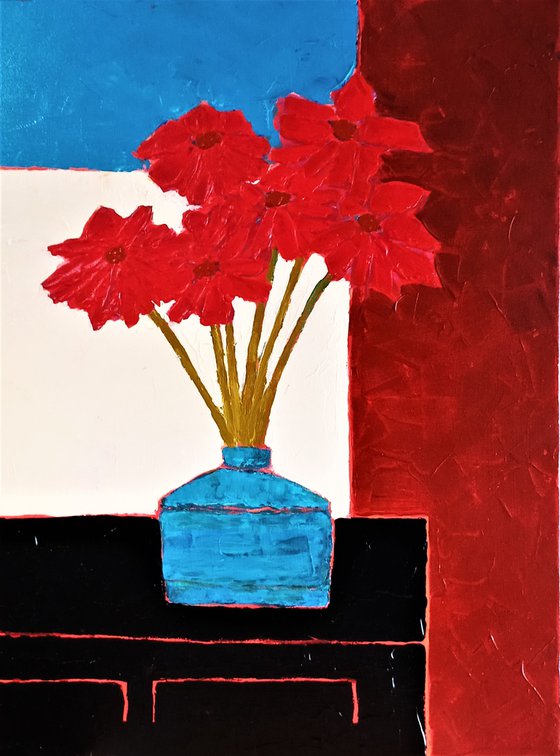 RED FLOWERS IN AN OLD BLUE VASE ON A BLACK CREDENZA