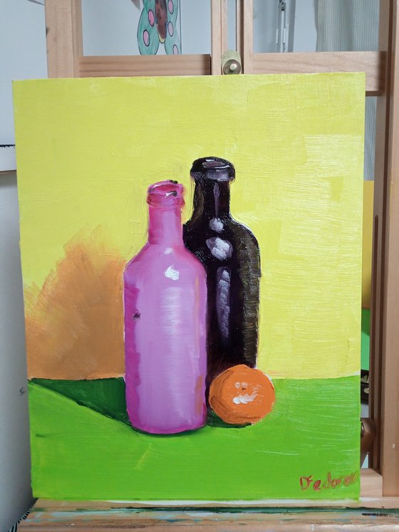 Colourful still life with two bottles and an orange tangerine