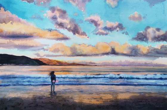 Young girl with skateboard walking on the beach