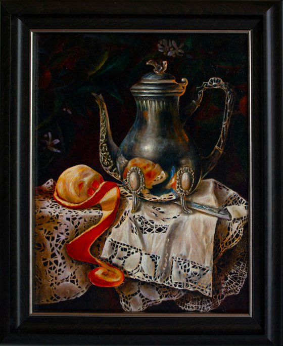Silver coffee pot with orange on a linen tablecloth