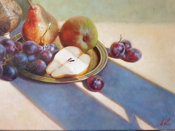 Fruits and a small brass jug.