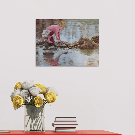 Girl in pink boots playing by a lake