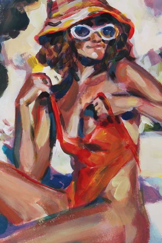 Girl in a red orange swimsuit and panama hat