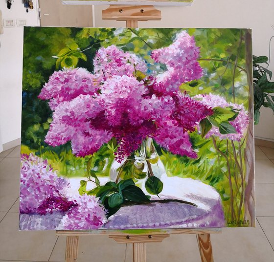 Lilac bouquet in a glass vase in the garden still life