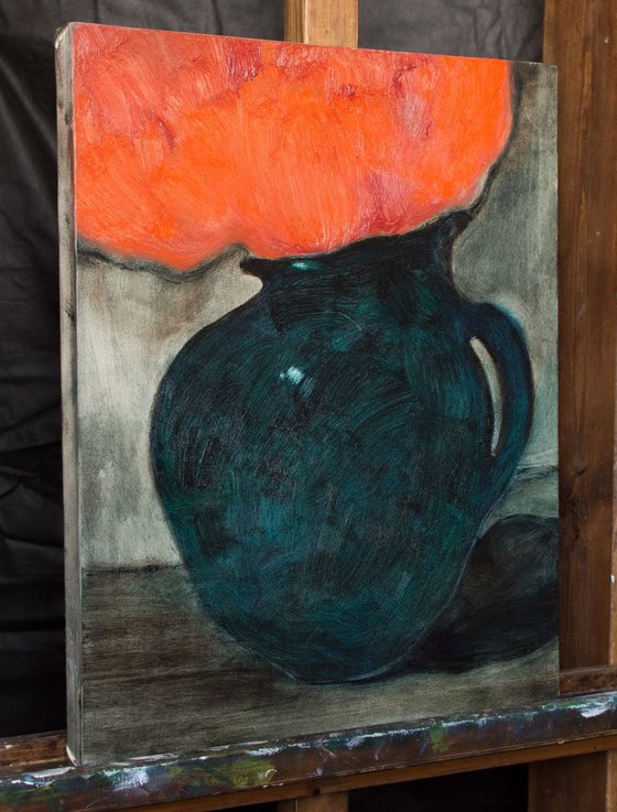 The green jug with a red flowers.